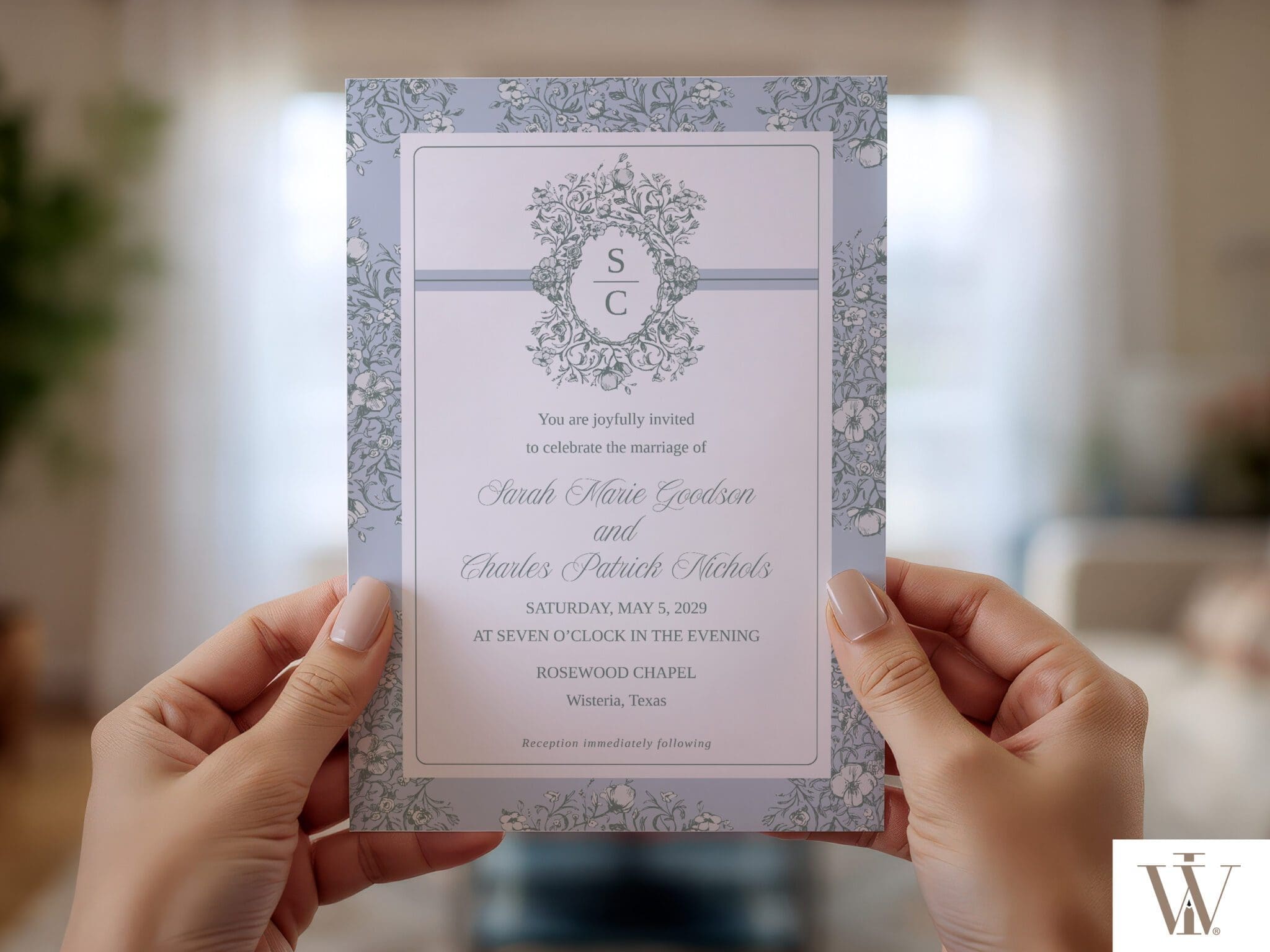 Hands holding Vintage Blooms wedding invitation with delicate floral border frame on white background